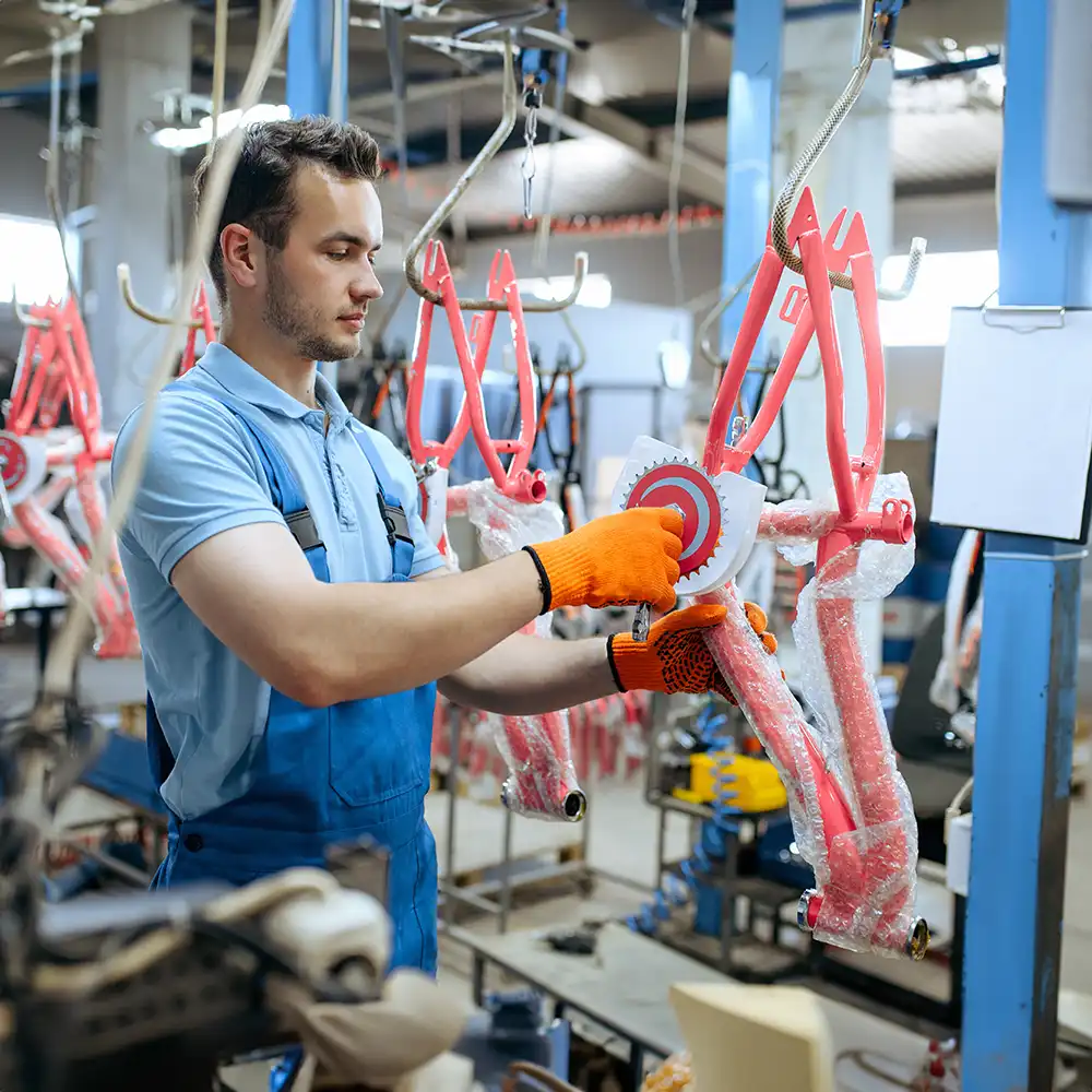 Fahrradfabrik, Arbeiter hält Kinderfahrradrahmen